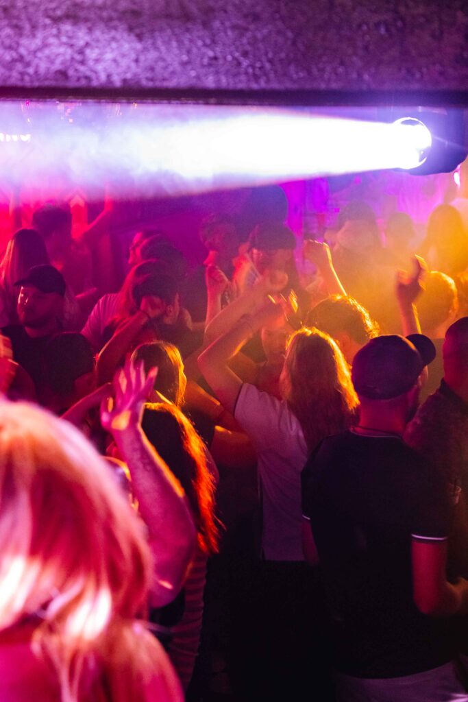 Guests dancing under pink lights inside Campus Liverpool
